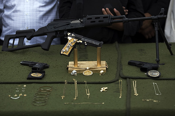 Guns and jewels seized during a military operation against organized crime are displayed to the media in Tijuana, Mexico.

