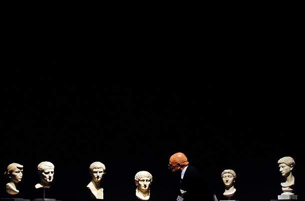 A visitor walks part sculptures of family members of Augustus, first emperor of the Roman Empire, at an exhibition in Germany.
