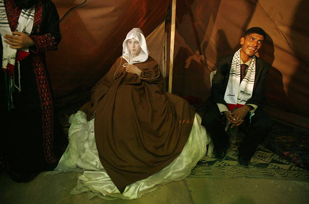 A Palestinian groom sits with his bride in a tent near his destroyed house during their wedding ceremony in Beit Hanoun in the Gaza Strip.