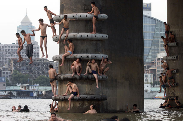 Men jump into the Yangtze river to cool off from the summer heat in Wuhan, China.