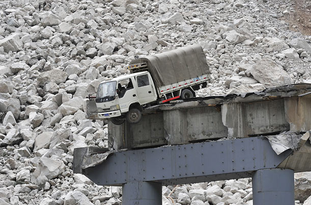 A truck dangles off the destroyed Chediguan Bridge near the epicenter of last year's May 12th earthquake in Wenchuan County, China.