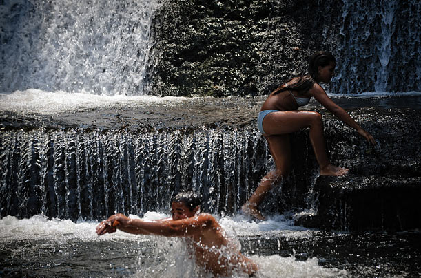 Bulgarians cool off in a waterfall during a heat wave near Sofia.