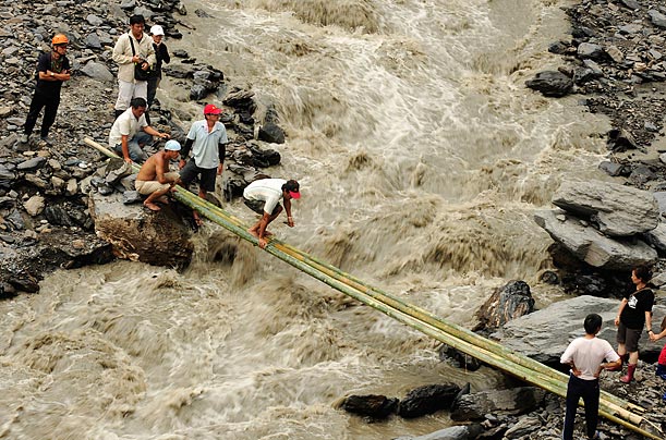 Getting Out Villagers stranded by a recent typhoon make their way across a makeshift bamboo bridge in Hsinfa village, Taiwan.