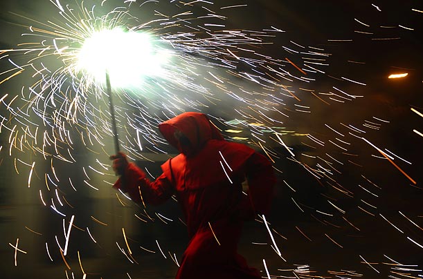 A reveler holds a torch as he takes part in Correfoc, or 