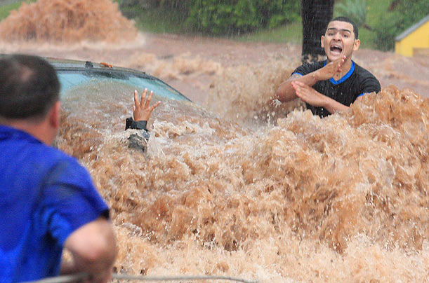 Emergency
A man shouts for help while trying to rescue a woman from the floods in Sao Jose do Rio Preto, Brazil.