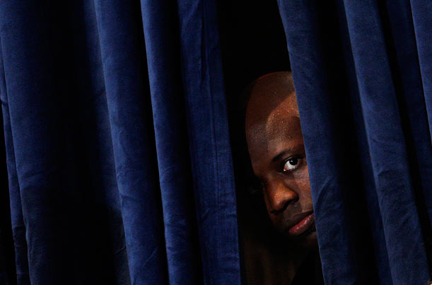 In the Wings
President Obama's personal aide Reggie Love peeks through a curtain as he waits for his boss to deliver remarks at a Democratic