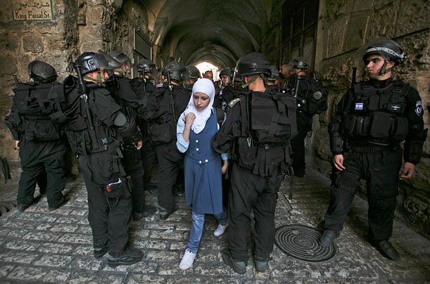 Show of Force
A Palestinian woman walks past Israeli policemen during clashes in Jerusalem's Old City.