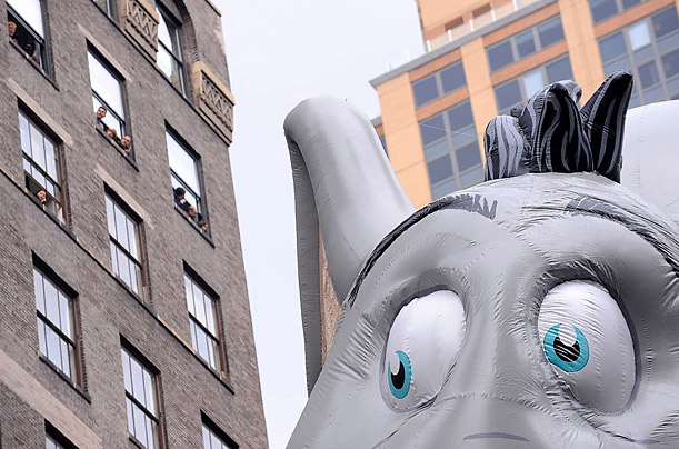 People watch the Horton the Elephant balloon from their windows in Manhattan high rises during the 83rd annual Macy's Thanksgiving Day parade on the Streets of Manhattan in New York City.