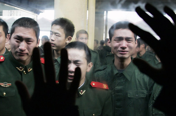 Former servicemen cry as they say goodbye to their fellow soldiers following the end of their army service term at a railway station in Shijiazhuang, Hebei province.
