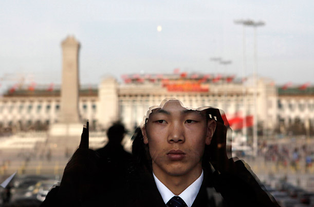 Pictures of the Week: A Chinese security personnel on duty is seen near reflections of Tiananmen Square on the glass door of the Great Hall of the People in Beijing