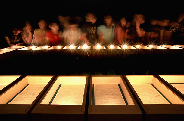 JERUSALEM - MARCH 09:  In an almost pitch-dark room, Israeli students inspect Albert Einstein's General Theory of Relativity on display in its entirety for the first