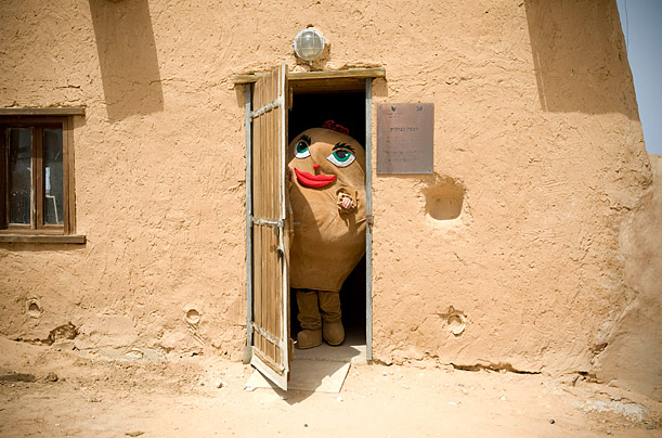 An actor wearing a potato costume stands in the doorway of a house during the Potato Festival in Mitzpe Gvulot, Israel.