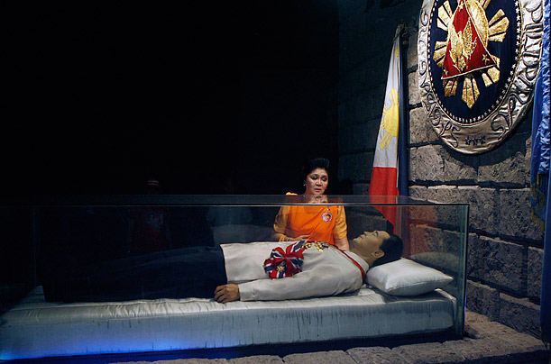 The former First Lady of the Philippines, Imelda Marcos, visits the glass coffin of her husband, late dictator Ferdinand Marcos, who remains unburied in Batac, Phillipines since his death in 1989.