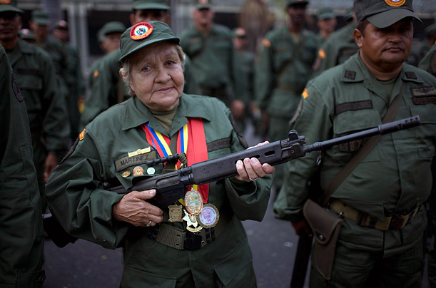 A member of the National Revolutionary Militia shows off her rifle during Militia Day in Caracas, Venezuela.