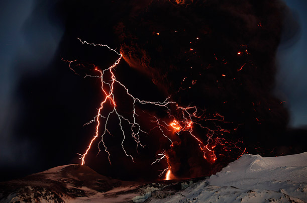 Lightning streaks across the sky as lava flows from the volcano on Iceland's Eyjafjallajokull glacier.