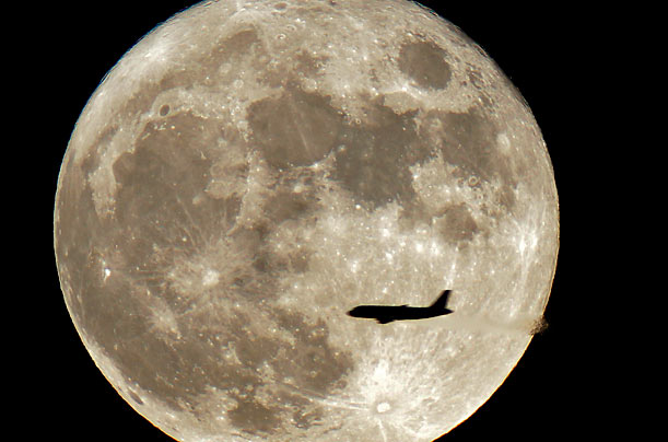 Satellite A jet is silhouetted on the full moon in St. Petersburg, Russia.