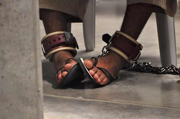 Guantanamo detainee is shackled to the floor as he attends a 