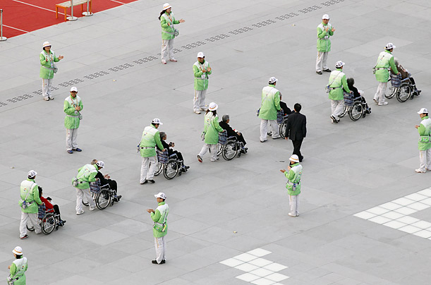 Guests in wheelchairs are assisted into the Shanghai World Expo.