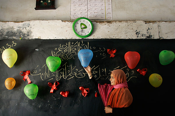 Appreciation. A student gives the final touches to classroom decorations in preparation for National Teacher's Day in Herat, Afghanistan.