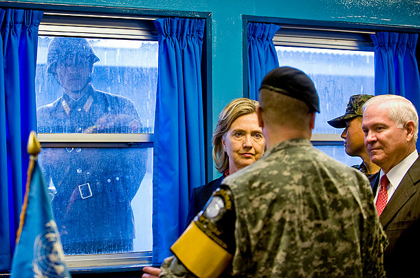 A North Korean soldier, left, looks through a window at Secretary of State Hillary Clinton, second from left, and Secretary of Defense Robert Gates, far right, while they visit the U.N. truce village
