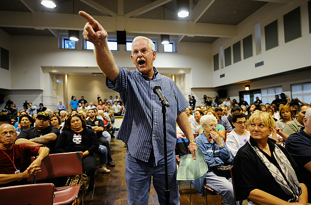 Resident Danny Harbor, points to city council members asking them to resign during a heated meeting in Bell, California.