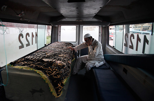 A relative of an Airblue plane crash victim places his hand over the casket inside an ambulance after the body arrived at Karachi's Jinnah International Airport.