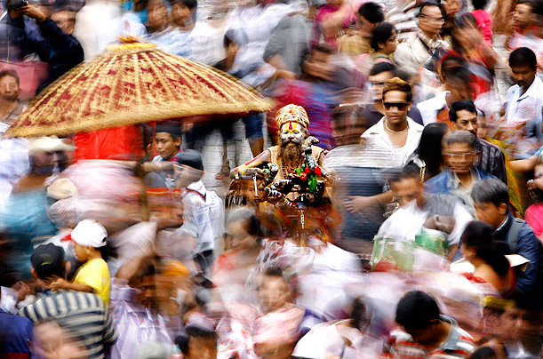 Passing By

A Hindu holy man in a wheelchair sits in the middle of the Gaijatra parade in Kathmandu, Nepal.
