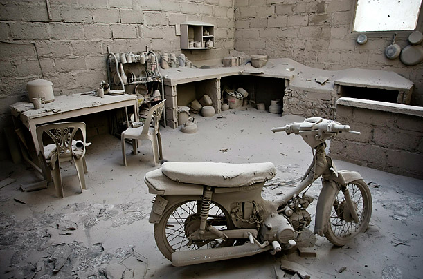 An ash-covered motorcycle sits in a home after the eruption of Mount Merapi in Indonesia. One of Indonesia's most active volcanoes spewed out clouds of ash and jets of searing gas, killing