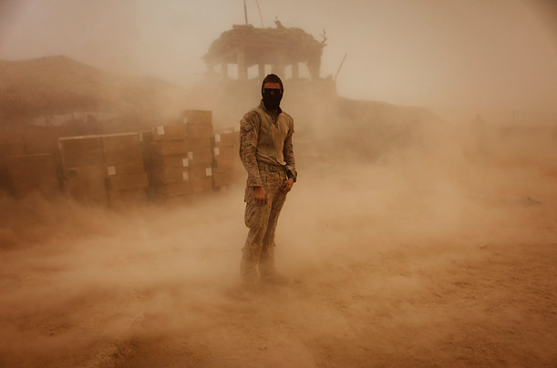Private First Class Brandon Voris, 19, of Lebanon, Ohio, stands in the middle of his camp as a sandstorm hits the remote outpost near Kunjak, in southern Afghanistan's Helmand province.