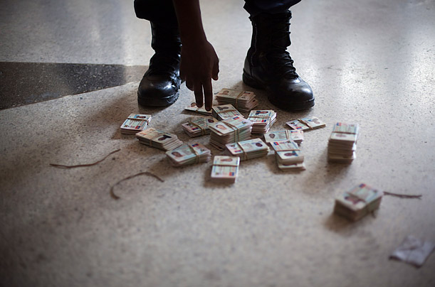 A Haitian police officer sorts though identification cards at a city hall in a neighborhood of Port-au-Prince.