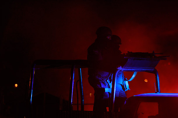 Federal police patrol near a brush fire after a shootout with officials in Ciudad Juarez, Mexico.

