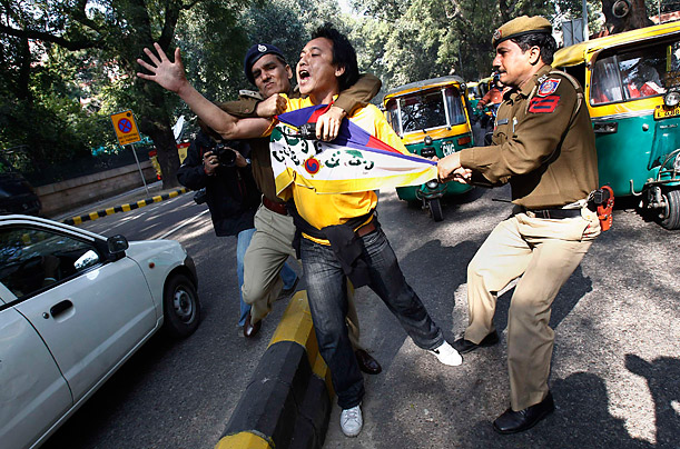 Police officers detain a Tibetan exile during a protest outside the venue of an India-China joint meeting in New Delhi.