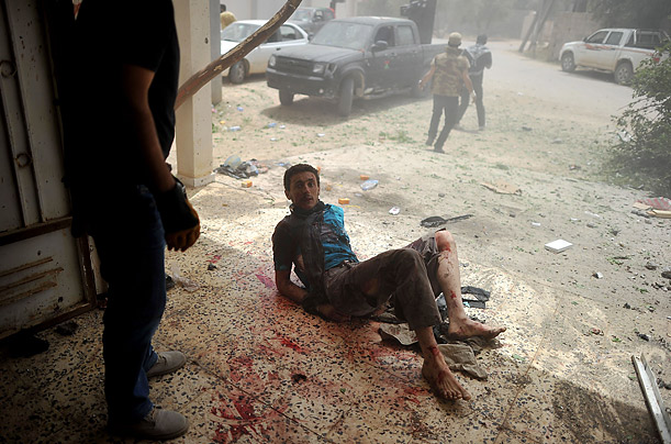 A Libyan rebel lies on the ground after being wounded by a mortar shell that killed two rebels during a battle with pro-Gaddafi forces in Al-Ghiran near Misrata airport. 
