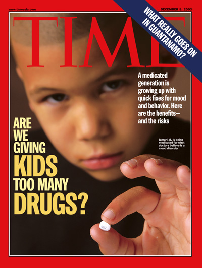 A photograph of a boy holding a pill.