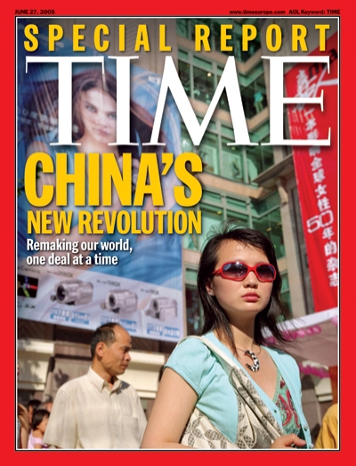 Picture of a Chinese woman wearing sunglasses with billboards behind her.