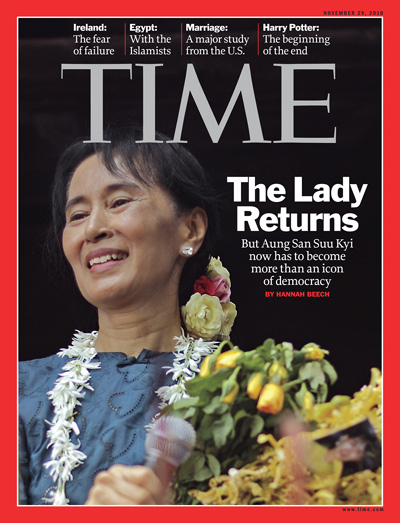 Aung San Suu Kyi holding microphone and flowers