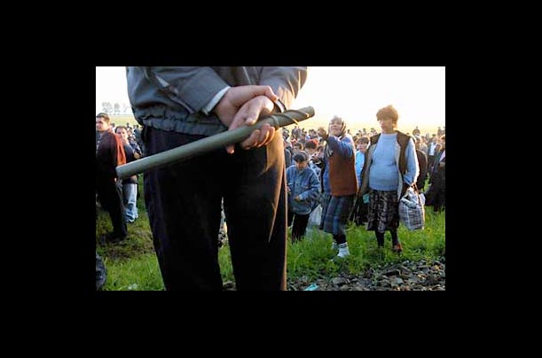 A Romanian woman gestures to a policeman following a police raid on a suburban train near Cernica