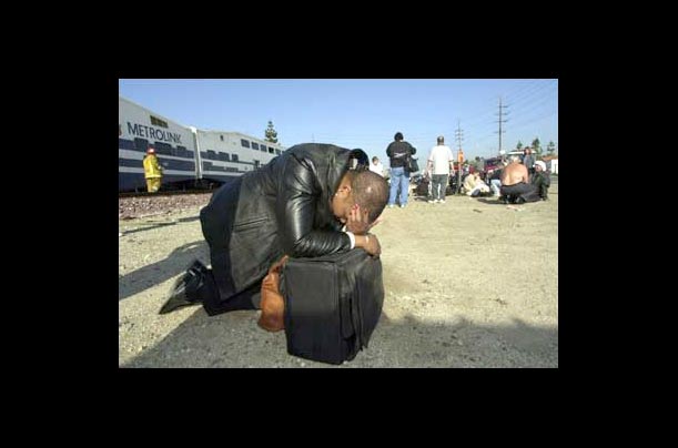 Passenger Brenda Lavender rests her head on luggage following the crash involving the Metrolink train she was riding and a freight train in Placentia, Calif