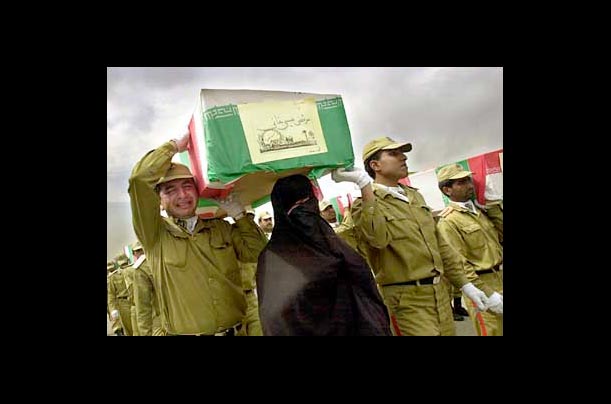 Iranian soldiers and a veiled female relative carry the coffin of Morteza Isakhani, who was killed during the Iran-Iraq war