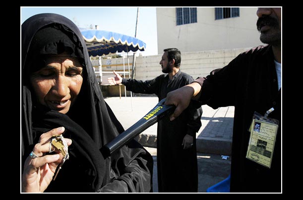 a woman displays keys at the entrance to the kadhim shrine in baghdad, where they are searched with metal detectors