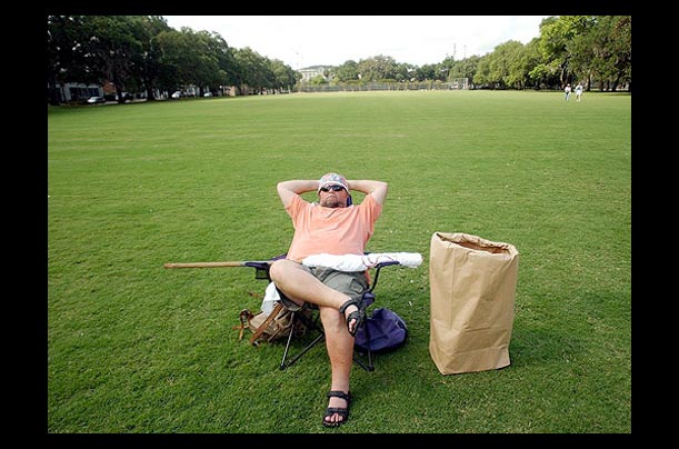 A lone protester sits in the middle of Forsyth Park in Savannah, Georgia waiting for other protesters to arrive during the opening day of the G8 Summit