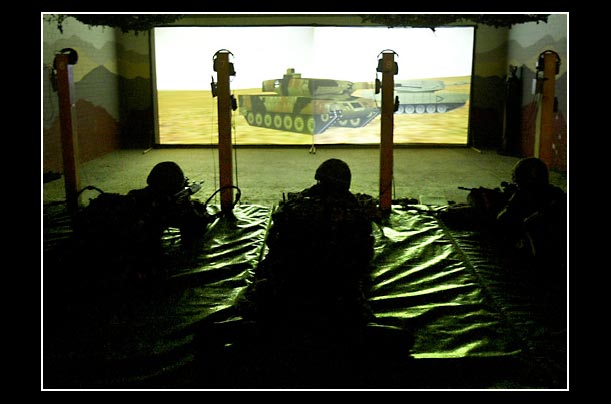 British Army soldiers take aim at a video screen displaying a battlefield scenerio at Wellington Barracks in London