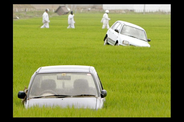 Cars in a rice paddy after being washed away by this week's torrential rains in Sanjo, Niigata prefecture, northern Japan