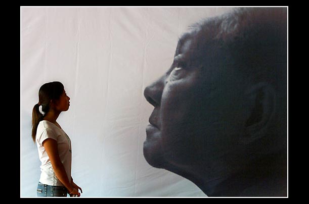 a chinese woman at an exhibition in hubei gallery in wuhan posing next to late leader deng xiaoping a chinese woman at an exhibition in hubei gallery in wuhan posing next to late leader deng xiaoping