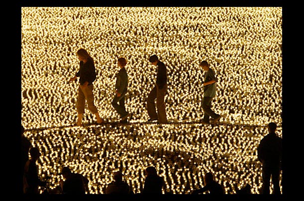 People walk between a light installation by artist Misha Bolourie called A Million Lights for the City Berlin