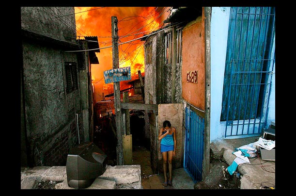 a distraught woman escapes a fire in Sao Paulo, Brazil, leaving many homeless