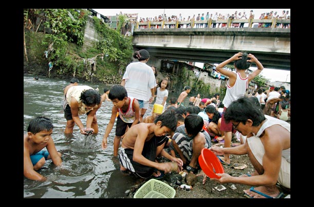 slum dwellers search for gold in the polluted river of quezon city, philippines