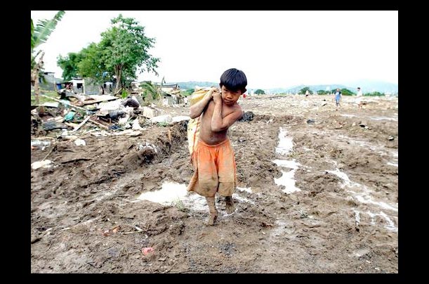 a filipino boy carries his belongings in the town of rodriguez, rizal province, philippines after flash floods