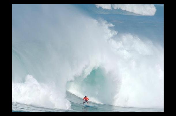 Rusty Keaulana of Hawaii surfs a large wave at the Eddie Aikau Invitational on Waimea Bay in Haleiwa, Hawaii