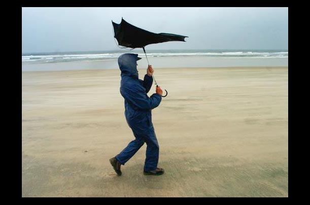 A woman protects herself from a rainstorm on Mission Beach in San Diego, California A woman protects herself from a rainstorm on Mission Beach in San Diego, California